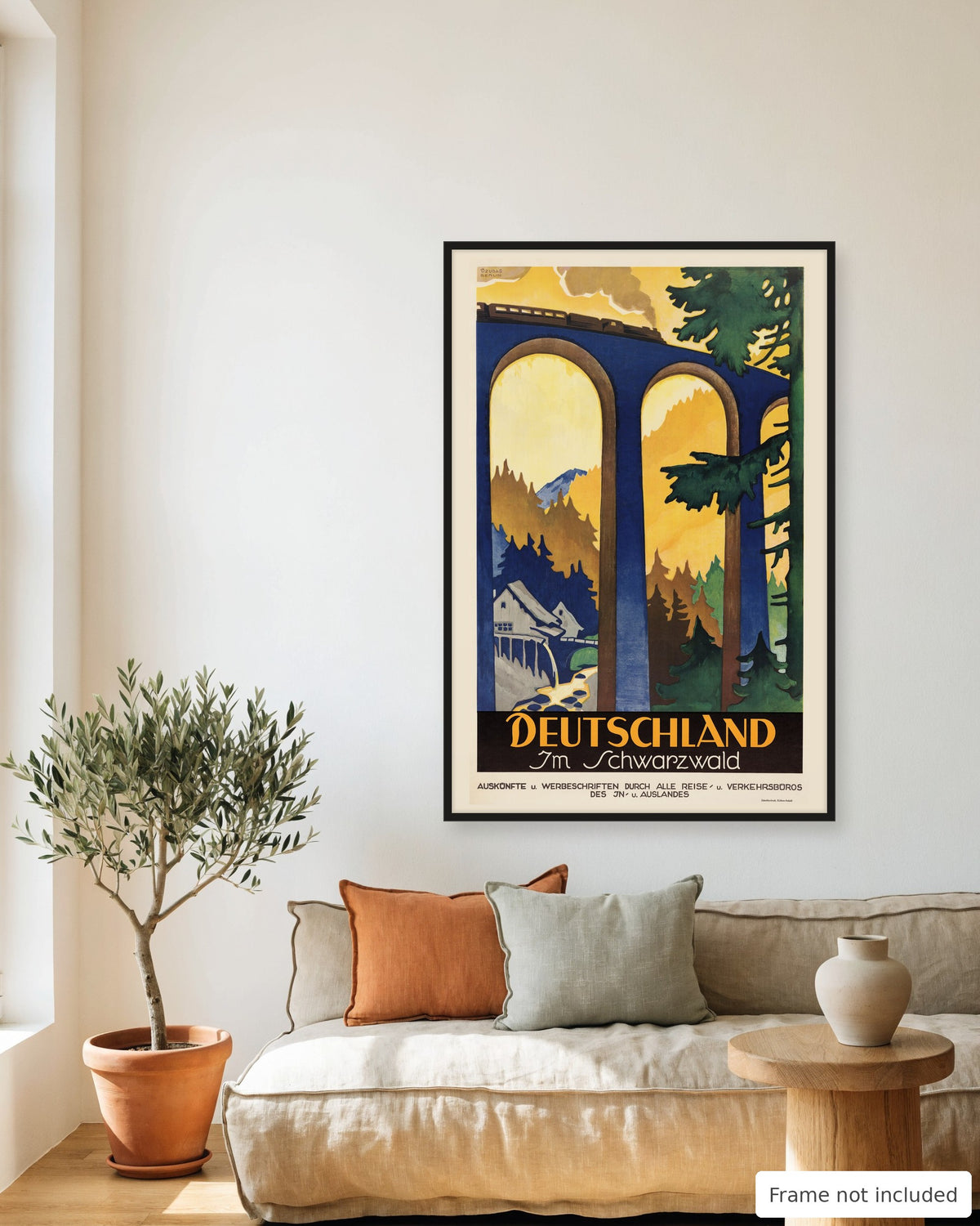 Black Forest vintage travel poster (1925) framed on a living room wall above a linen sofa