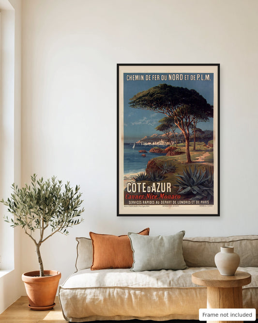 Cote d'Azur vintage travel poster (1897) framed on a living room wall above a linen sofa