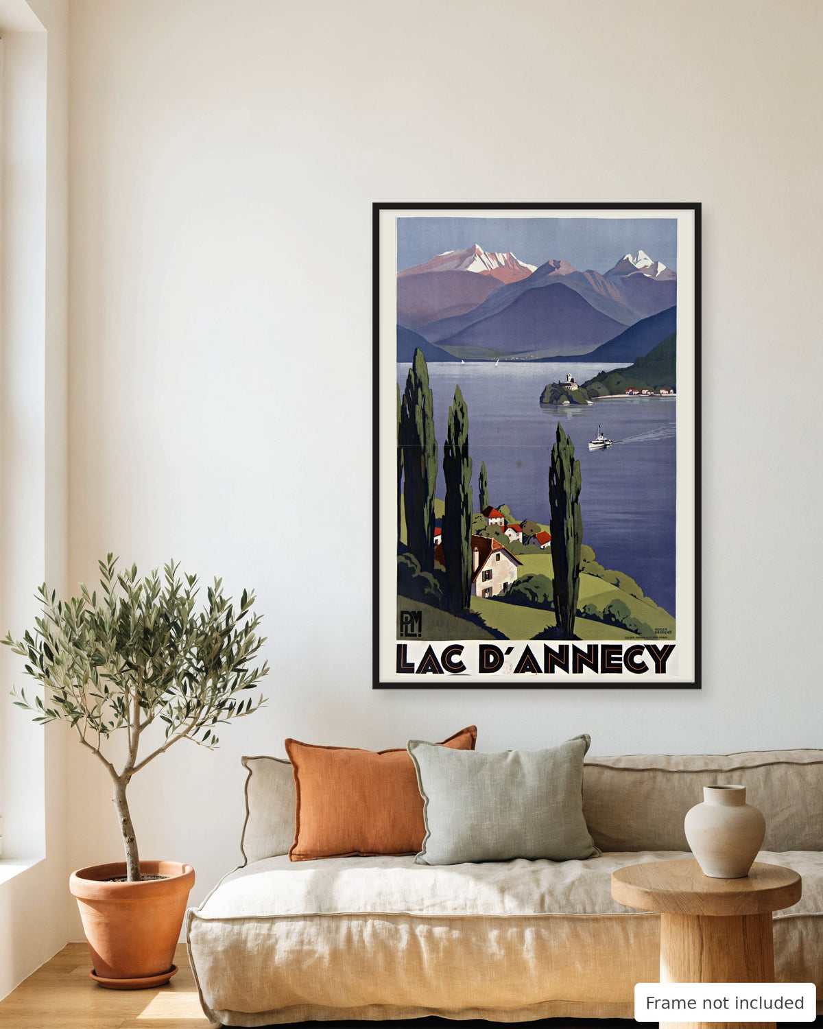 Lake Annecy vintage travel poster (1930) framed on a living room wall above a linen sofa