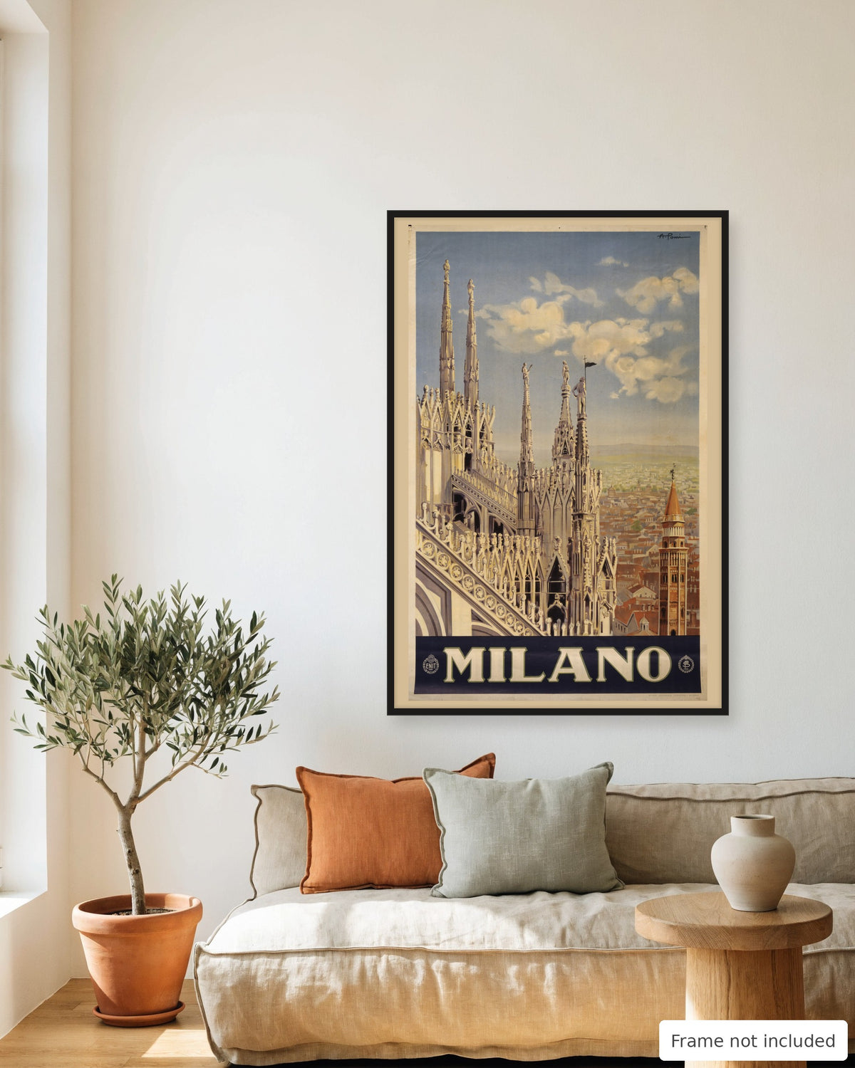 Milan vintage travel poster (1920) framed on a living room wall above a linen sofa