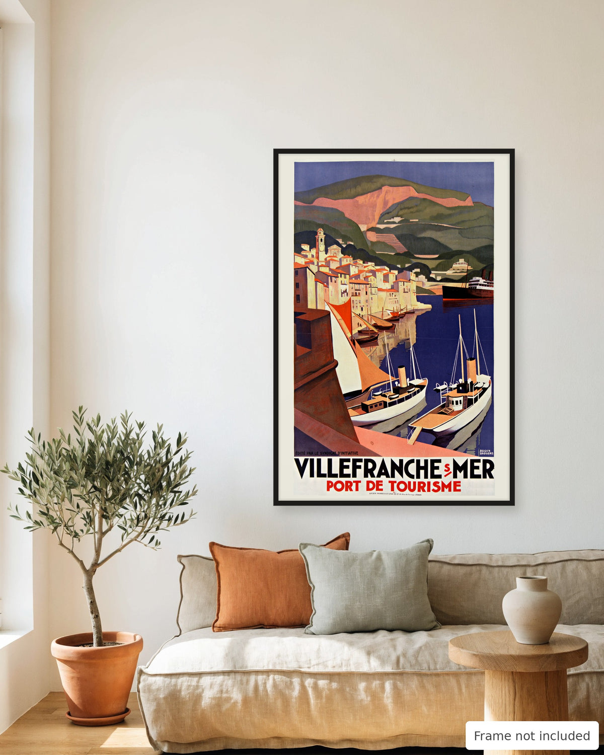 Villefranche-sur-Mer vintage travel poster (1929) framed on a living room wall above a linen sofa
