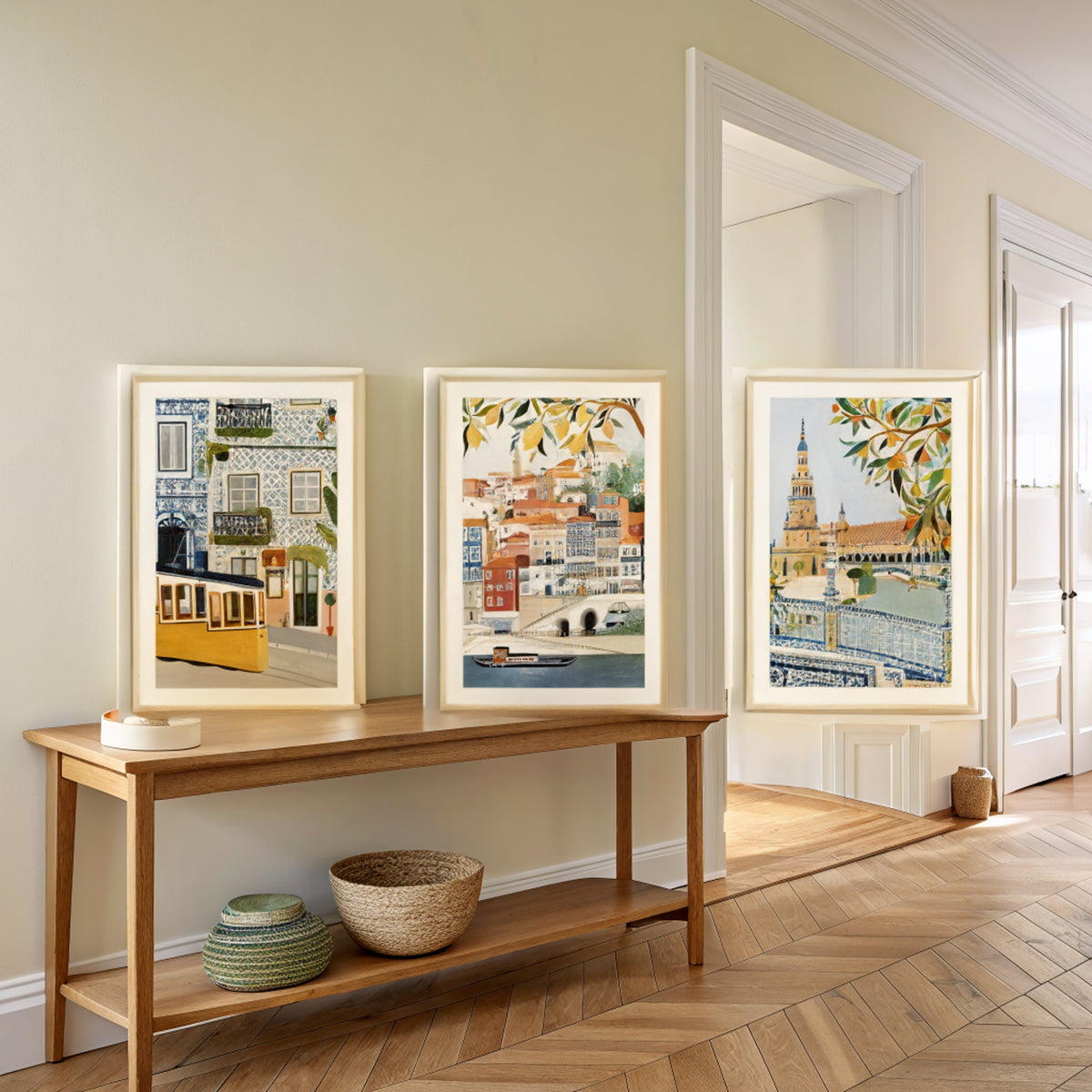 Three Iberia travel prints above an oak console table in an entryway