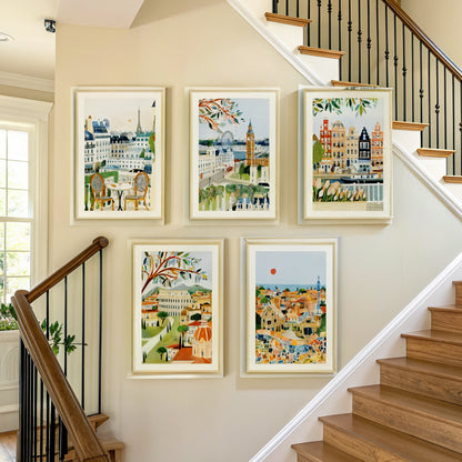 Five European city prints arranged on a staircase wall