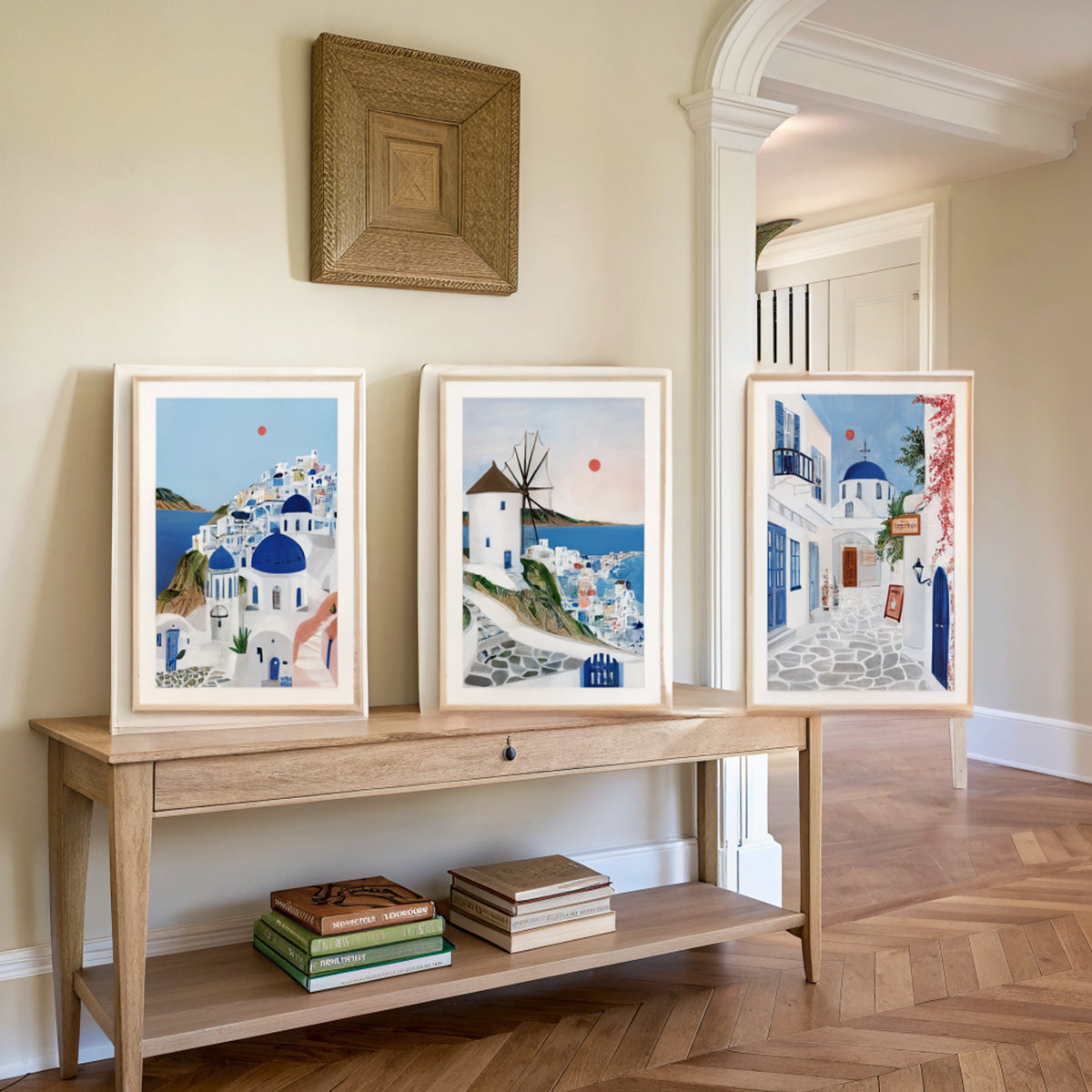 Three Greek island prints above an oak console table in an entryway